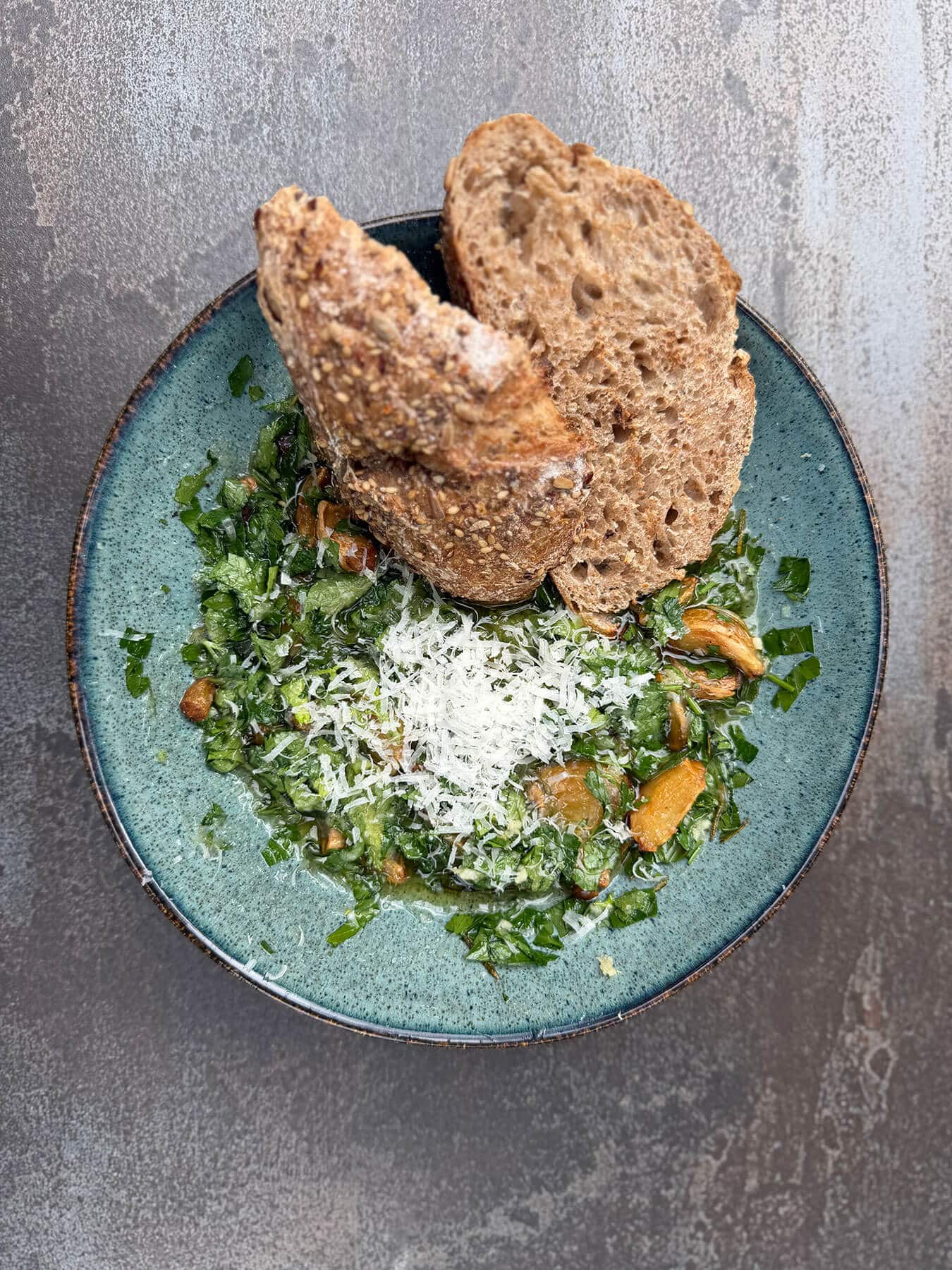Groene salade met brood en Parmezaanse kaas op een blauw bord - Dutch BBQ Dude