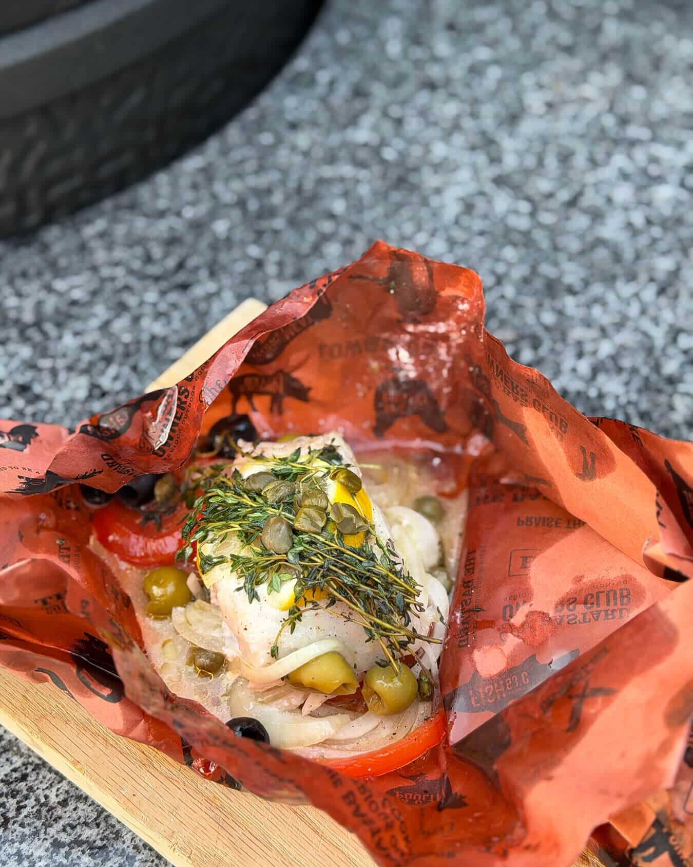Kabeljauwhaas en papillote met groenten, kappertjes, olijven en kruiden op oranje bakpapier - Dutch BBQ Dude