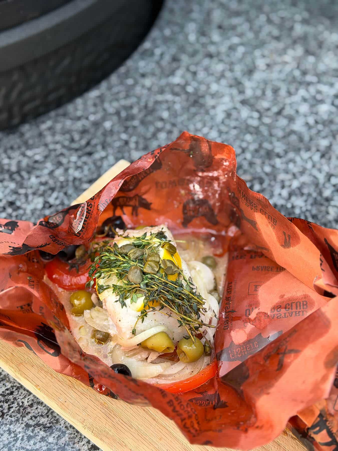 Kabeljauwhaas en papillote met groenten, kappertjes, olijven en kruiden op oranje bakpapier - Dutch BBQ Dude