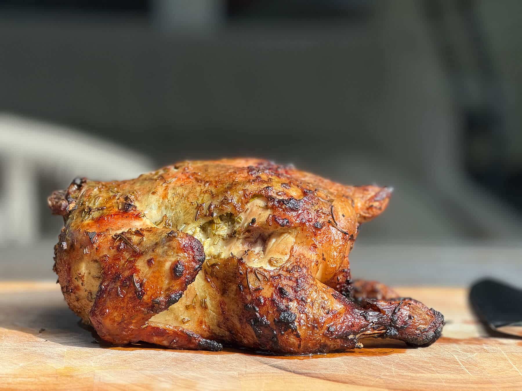 Geroosterde kip met kruiden op een houten plank - Dutch BBQ Dude