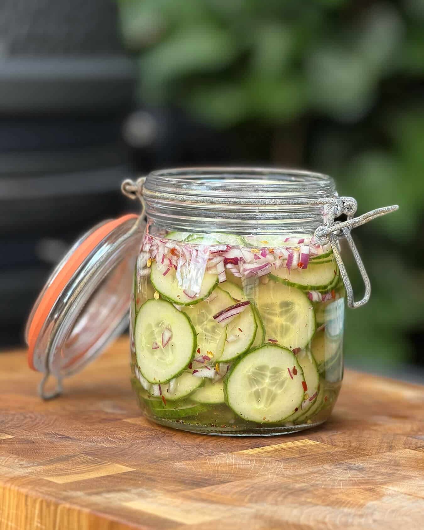 Zelfgemaakte ingemaakte komkommers in een weckpot met rode ui en chilipeper. - Dutch BBQ Dude